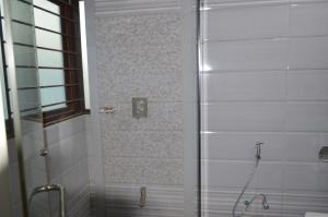 y baño con ducha y puerta de cristal. en Rose Valet Guest House, en Islamabad