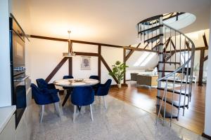 a dining room with a table and blue chairs at Apartament Loftowy Ordona 5 in Szczecinek