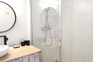 uma casa de banho branca com um chuveiro e um lavatório. em Agréable 2 pièces à Savigny sur Orge em Savigny-sur-Orge