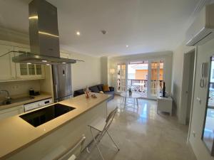 a kitchen and living room with a counter and chairs at MONTE CARRERA Sunrise & Sunset in Mogán