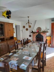 Casa Irene per famiglie e gruppi con piscina في Lugliano: غرفة طعام مع طاولة مع كراسي ومدفأة