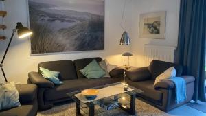 ein Wohnzimmer mit einem Sofa und einem Tisch in der Unterkunft Ferienhaus Sandmann Greetsiel in Greetsiel