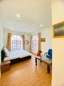 a bedroom with a bed and a table and two windows at Pall Residency in Srinagar