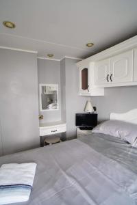een slaapkamer met een groot bed en witte kasten bij 2 bedroom two bathroom sunset lodge heachambeach in Heacham +24 foto's