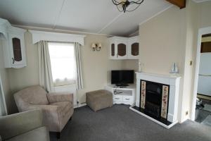 een woonkamer met open haard en tv bij 2 bedroom two bathroom sunset lodge heachambeach in Heacham