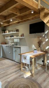 a kitchen with a wooden table and a tv on the wall at Domek SzumiSosna2 in Życiny