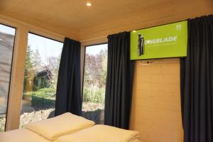 - un panneau dans une chambre avec un lit et une fenêtre dans l'établissement Casuta Cires - Therme & Aeroport Otopeni, à Corbeanca