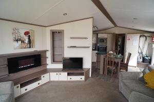 a living room with a flat screen tv and a couch at pets stay free 8 berth lux van heacham beach in Heacham