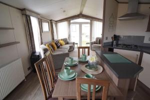 a kitchen and living room with a table and chairs at pets stay free 8 berth lux van heacham beach in Heacham