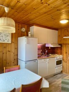 a kitchen with a white refrigerator and a table at Lya med utsikt in Henån