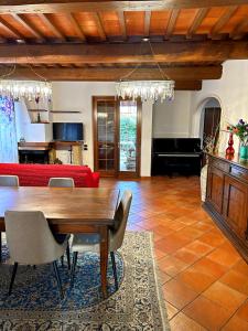 sala de estar con mesa de madera y sofá rojo en Villa Giovannino tra Firenze, Arezzo e Siena, en Terranuova Bracciolini