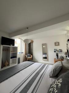 ein Schlafzimmer mit einem großen weißen Bett in einem Zimmer in der Unterkunft La petite maison in Gasny