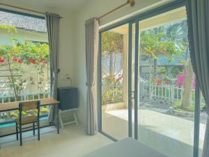 an open glass door to a patio with a table at Paradise Resort Doc Let in Doc Let