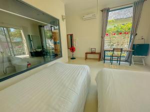 1 dormitorio con cama blanca y espejo grande en Paradise Resort Doc Let, en Doc Let
