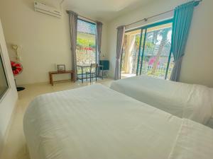 een slaapkamer met 2 witte bedden en een raam bij Paradise Resort Doc Let in Doc Let