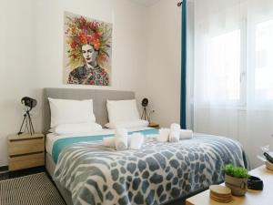 um quarto com uma cama com um quadro na parede em Artzy petit apartment close to the center em Heraclião