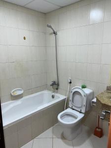 a bathroom with a toilet and a bath tub at Ft 22 R1 Luxury Room attach bath Seaview Beach access Ajman غرفة فاخرة مع إطلالة على البحر وإمكانية الوصول إلى الشاطئ in Ajman 