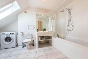 y baño blanco con lavabo y lavadora. en Nouveau - La Bulle Lumineuse - Terrasse, en Brumath