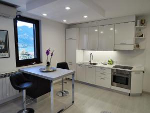a kitchen with white cabinets and a table with chairs at Appartamento La Terrazza - Paratico - in Paratico