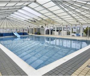 a large swimming pool with a glass ceiling at Stunning river view 2 bedroom caravan with decking in Hunstanton