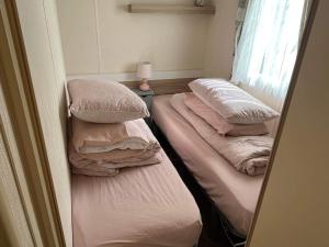 Rúm í herbergi á Budget 3 Bedroom Caravan with Decking at Heacham