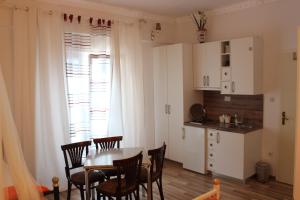 a kitchen and dining room with a table and chairs at Pansion Ana in Podaca