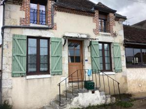 une maison avec des volets verts et une porte dans l'établissement Auberge des 7 ecluses, à Rogny