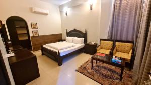 a bedroom with a bed and a couch and a table at Shelton Hotel & Restaurant in Sarai