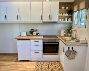 a kitchen with white cabinets and a sink at Oliva - 1 bedroom apartment in Benitses +14 photos