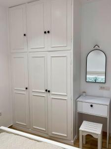a white closet with a table and a mirror at Oliva - 1 bedroom apartment in Benitses