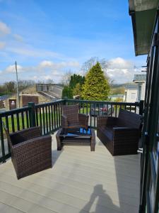 terraza con sillas de mimbre y mesas en el balcón en Nick's Retreat, en Clitheroe