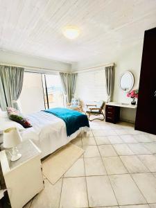 a bedroom with a large bed and a desk at Skilpadtepel in Hentiesbaai