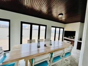 a dining room with a large wooden table and chairs at Skilpadtepel in Hentiesbaai