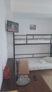 ein Schlafzimmer mit einem Etagenbett und einem Tisch mit Brille in der Unterkunft Taxi Hostel in Otopeni