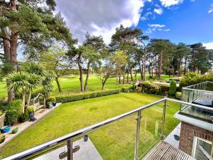 a view of a yard from the balcony of a house at Golf Course View - Large Four Bed Home with Garden and Parking - New Forest and Beach Links in Ferndown