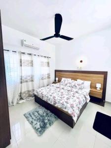 - une chambre avec un lit et un ventilateur de plafond dans l'établissement Timba-Pekinoracom, à Cotonou