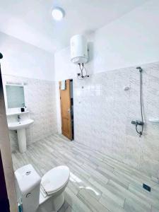 a bathroom with a toilet and a sink and a shower at Timba-Pekinoracom in Cotonou