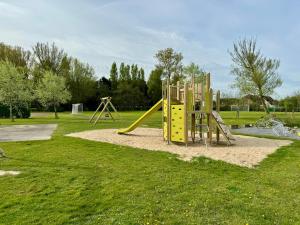 a playground with a slide in a park at De Haan - Dahlia 007 in De Haan