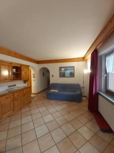 um quarto com uma cama e piso em azulejo em Majon Di Roces em Canazei