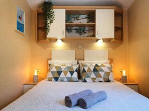 um quarto com uma cama com duas toalhas azuis em Chalet Melrose - Camping Parc Valrose em La Londe-les-Maures