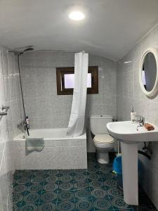łazienka z umywalką, toaletą i wanną w obiekcie Loft Rural w Barcelonie