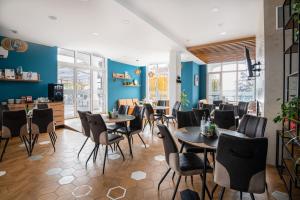 巴爾奇克的住宿－Hotel Samara with Relax area，餐厅设有桌椅和蓝色的墙壁