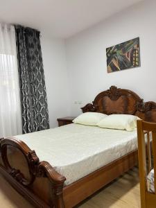 ein Schlafzimmer mit einem Holzbett und einem Fenster in der Unterkunft Glauk Apartment in Berat
