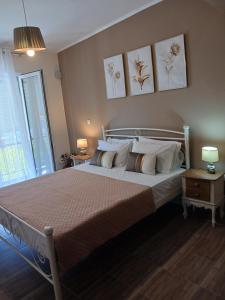 um quarto com uma cama grande com três fotografias na parede em Joannas Luxury Apartment em Corfu Town