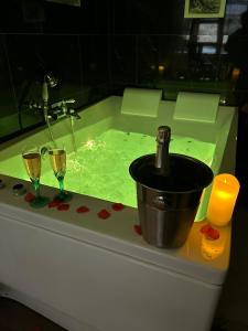 - une baignoire avec une bouteille de champagne et 2 verres dans l'établissement La Casa d'Ailleurs BERRY SEJOURS, à Châteauroux