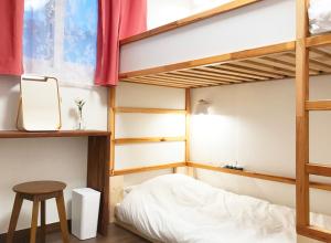 a bedroom with bunk beds with a stool and a table at Eoulim Guesthouse 2 in Andong
