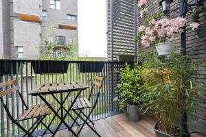 a balcony with a wooden table and chairs and plants at Joli appartement dans Eco quartier résidentiel in Saint-Ouen