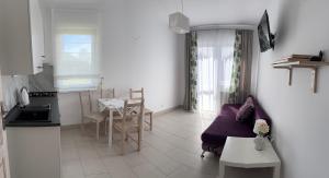 a kitchen and a living room with a couch and a table at Marina in Jarosławiec