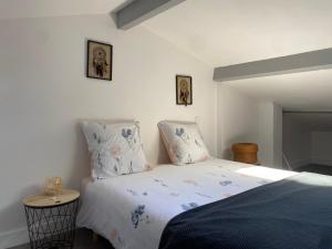 Gite d'ici et d'ailleurs 2 في Saint-Morillon: غرفة نوم بسرير وصورتين على الحائط