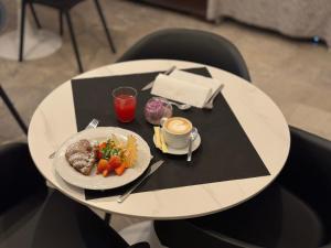 a white table with a plate of food on it at Relais Stibbert Florence in Florence